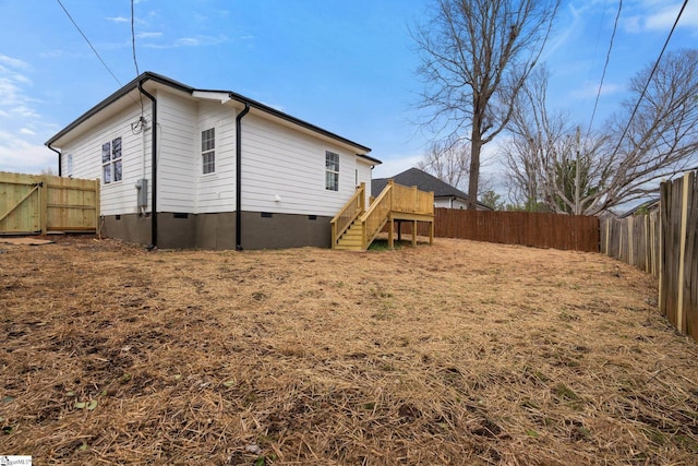 back of house featuring stairs, a deck, crawl space, and a fenced backyard