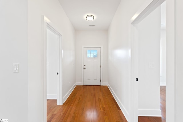 doorway to outside with baseboards and wood finished floors