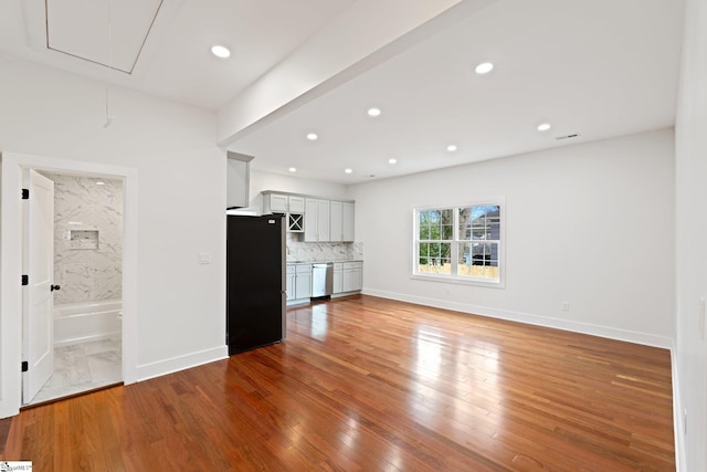 unfurnished living room featuring attic access, recessed lighting, light wood-style floors, and baseboards