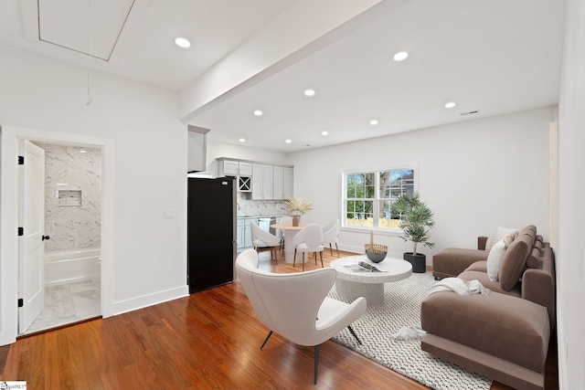 living room featuring attic access, baseboards, wood finished floors, and recessed lighting