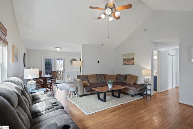 living room with french doors, a ceiling fan, high vaulted ceiling, baseboards, and hardwood / wood-style flooring