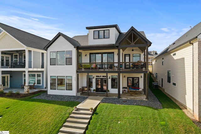 back of house featuring ceiling fan, french doors, a lawn, and a patio