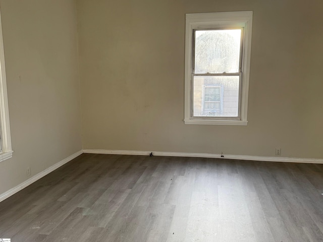 spare room featuring baseboards and wood finished floors