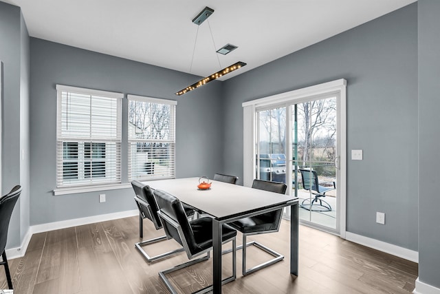 dining space featuring visible vents, baseboards, and wood finished floors