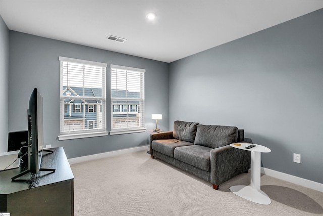 living area with carpet, visible vents, and baseboards