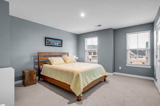 bedroom featuring light colored carpet, visible vents, and baseboards