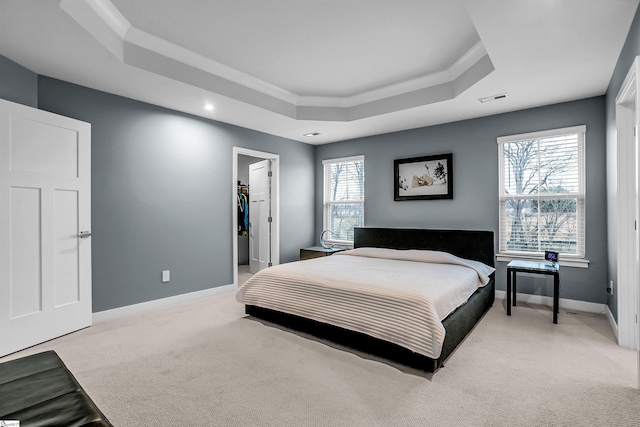 bedroom with multiple windows, a raised ceiling, visible vents, and baseboards