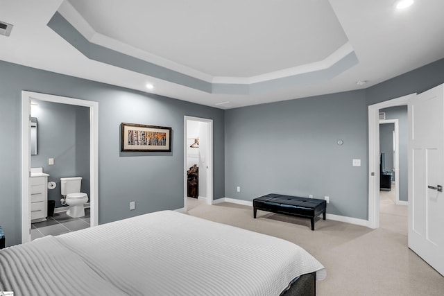 bedroom with a tray ceiling, light carpet, and baseboards