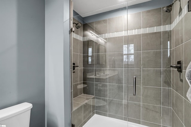 bathroom with a shower stall and toilet