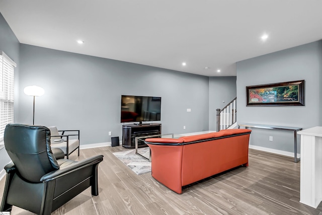 living room with recessed lighting, baseboards, light wood finished floors, and stairs