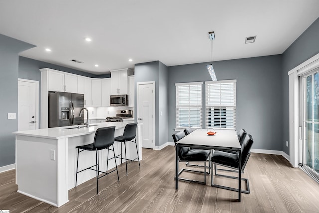 kitchen featuring baseboards, appliances with stainless steel finishes, and light wood-style floors