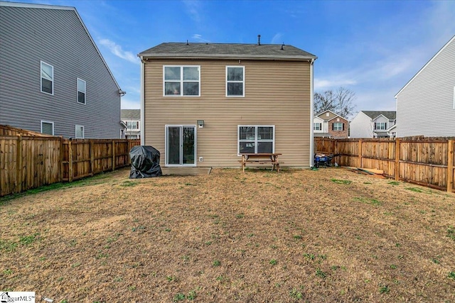 back of house featuring a lawn and a fenced backyard