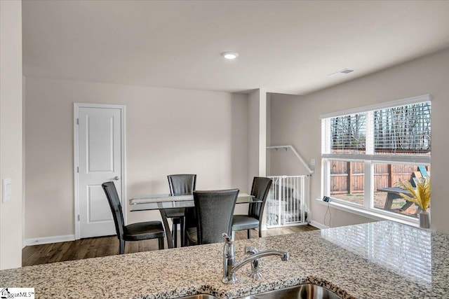 dining area featuring wood finished floors, visible vents, and baseboards