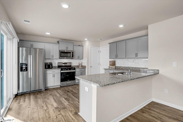 kitchen with visible vents, appliances with stainless steel finishes, a sink, and gray cabinetry