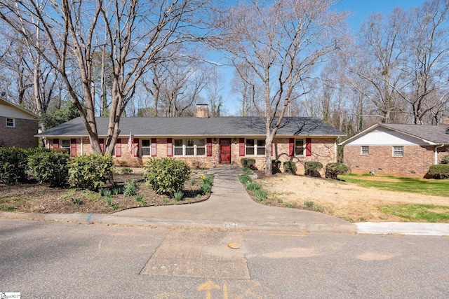 ranch-style home featuring crawl space, a chimney, and brick siding