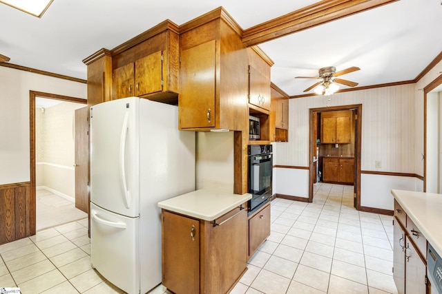 kitchen featuring light countertops, stainless steel microwave, ornamental molding, freestanding refrigerator, and black oven