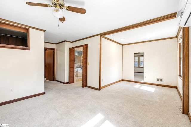 carpeted empty room with baseboards, visible vents, crown molding, and a wall mounted air conditioner