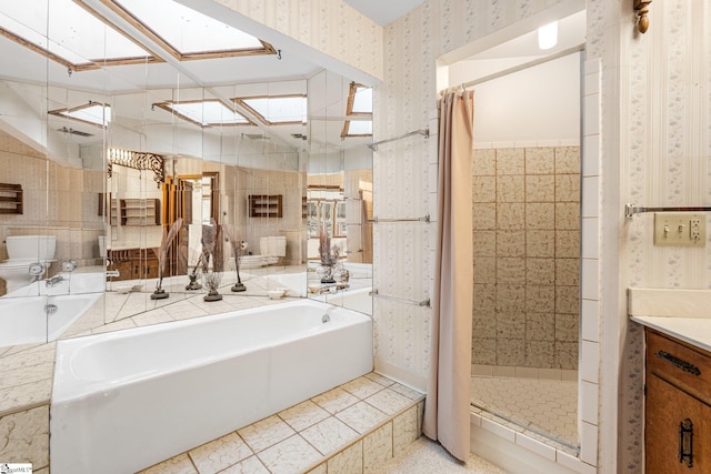 bathroom featuring a skylight, a shower stall, and wallpapered walls