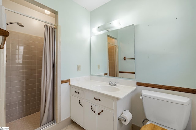 bathroom with toilet, a stall shower, and vanity