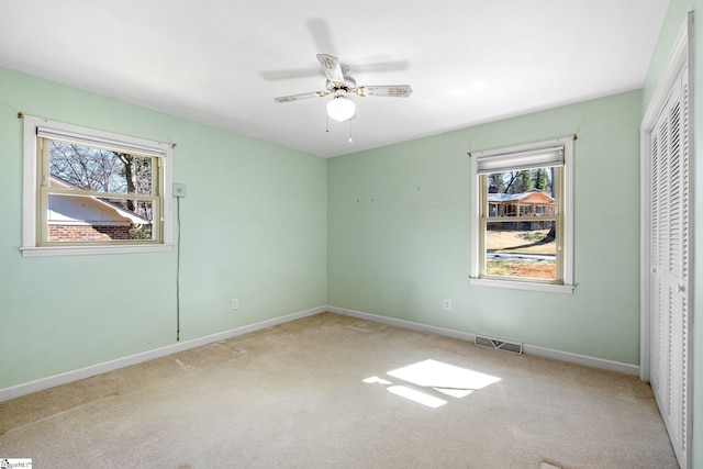 unfurnished bedroom with carpet floors, a ceiling fan, visible vents, baseboards, and a closet