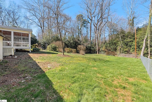 view of yard with a sunroom and fence