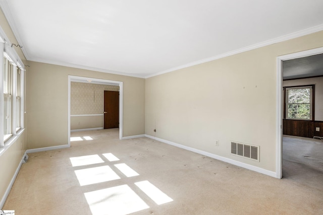 unfurnished room featuring light carpet, baseboards, visible vents, and crown molding