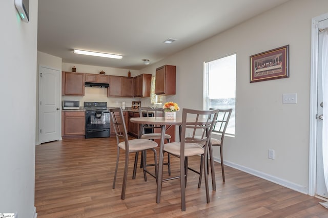 dining space with visible vents, baseboards, and wood finished floors