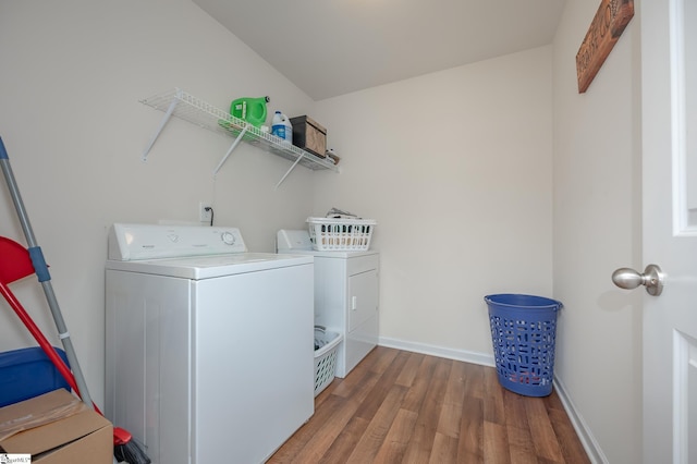 laundry area featuring laundry area, baseboards, washer and dryer, and wood finished floors