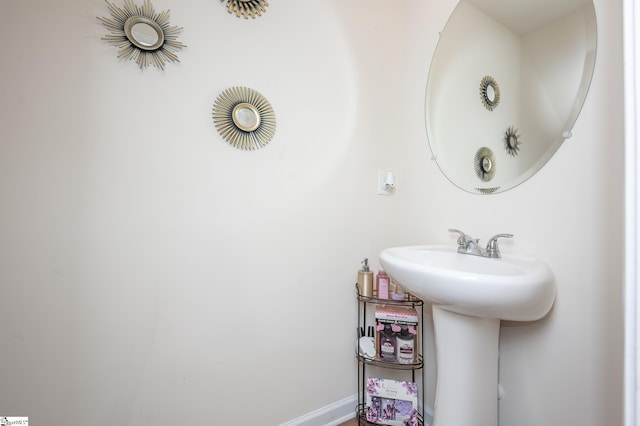 bathroom featuring baseboards and a sink