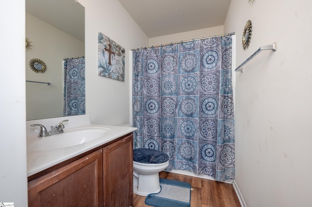 full bath with toilet, a shower with shower curtain, wood finished floors, and vanity