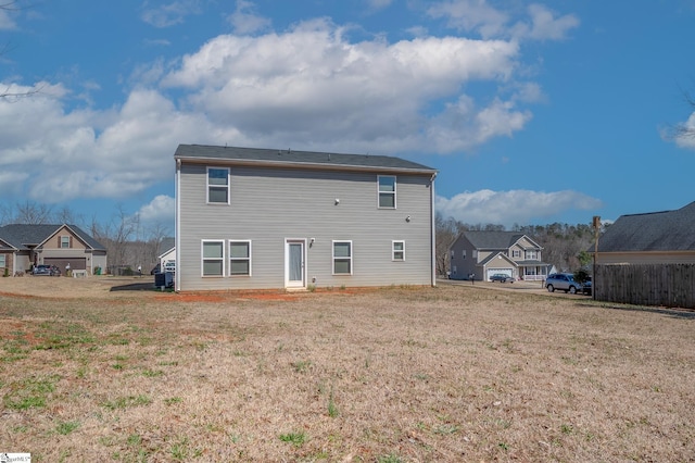 rear view of property featuring a lawn