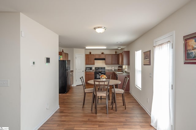 dining room with plenty of natural light, baseboards, and wood finished floors