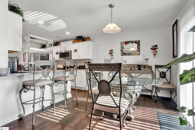 dining space featuring dark wood-style floors