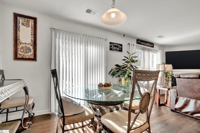 dining room featuring baseboards, visible vents, and dark wood finished floors