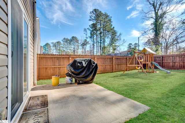 view of yard featuring a patio area, a playground, and a fenced backyard