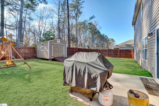 view of yard featuring a playground, a patio area, a shed, a fenced backyard, and an outdoor structure