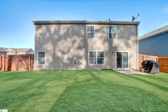 rear view of property with a fenced backyard and a yard