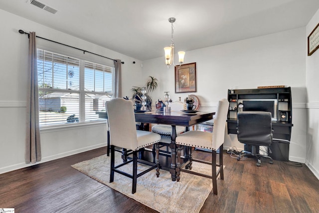 dining space with an inviting chandelier, visible vents, baseboards, and wood finished floors