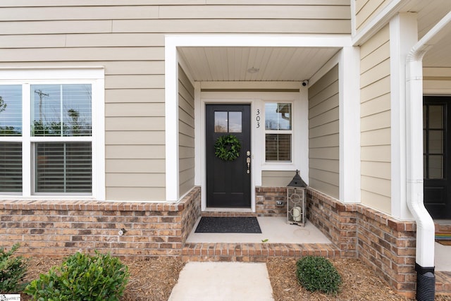 doorway to property with brick siding