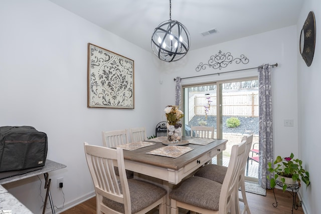 dining room with baseboards, visible vents, an inviting chandelier, and wood finished floors