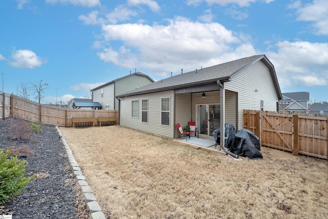 rear view of property featuring a shingled roof, a patio area, a fenced backyard, and a ceiling fan