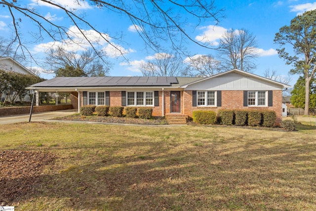 ranch-style home featuring a carport, brick siding, and a front yard