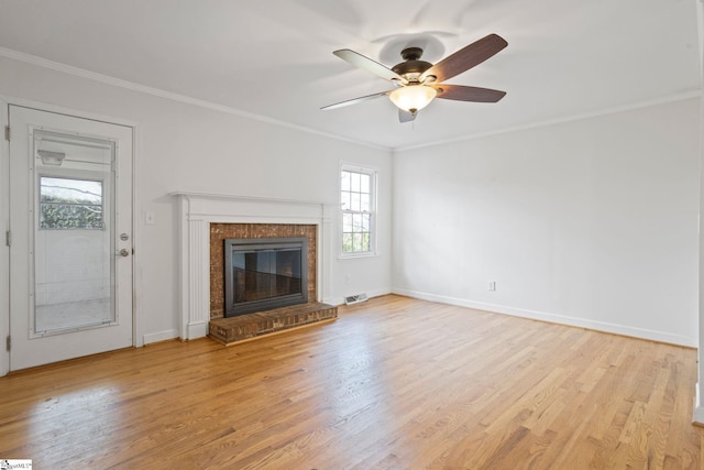 unfurnished living room featuring ornamental molding, a fireplace, light wood-style flooring, and baseboards