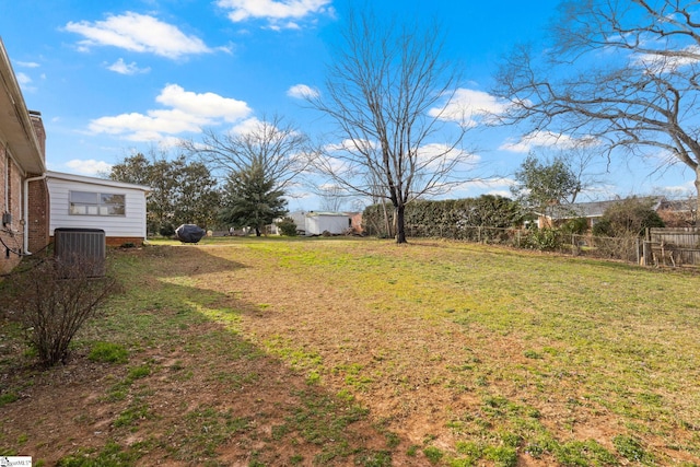 view of yard with central air condition unit and fence