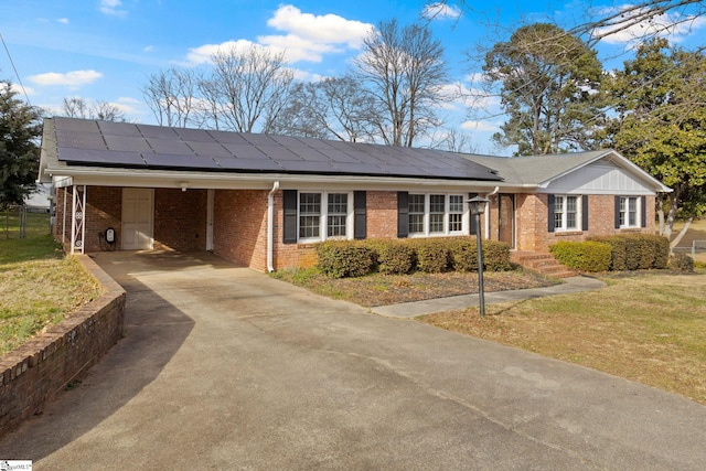 single story home featuring concrete driveway, brick siding, a front lawn, and solar panels