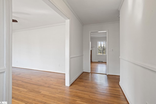 corridor featuring crown molding, baseboards, and wood finished floors