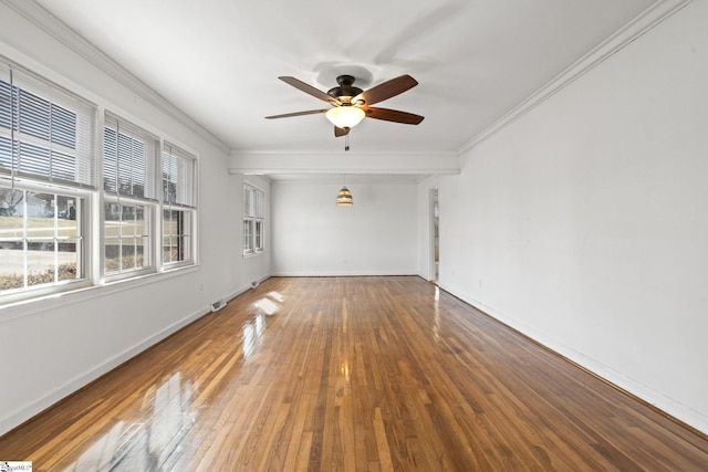 empty room with hardwood / wood-style flooring, baseboards, ornamental molding, and ceiling fan