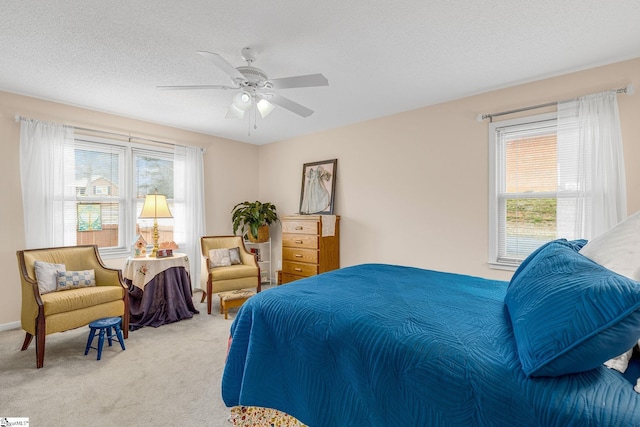 bedroom featuring carpet floors, ceiling fan, and a textured ceiling