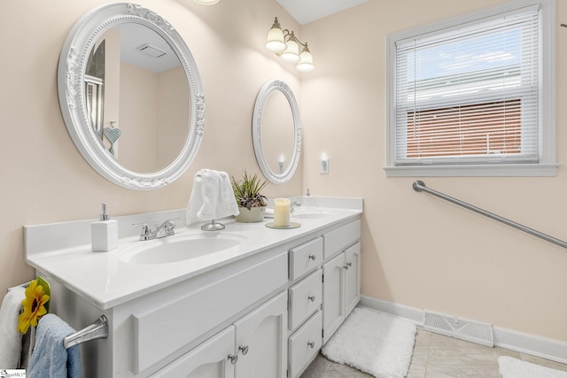 bathroom with double vanity, baseboards, visible vents, tile patterned flooring, and a sink