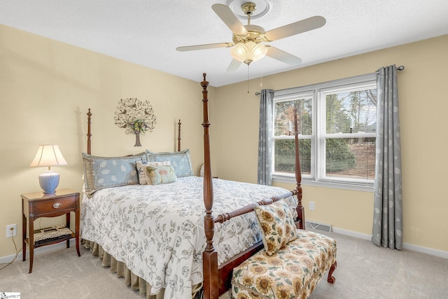 bedroom with visible vents, baseboards, a ceiling fan, light colored carpet, and a textured ceiling